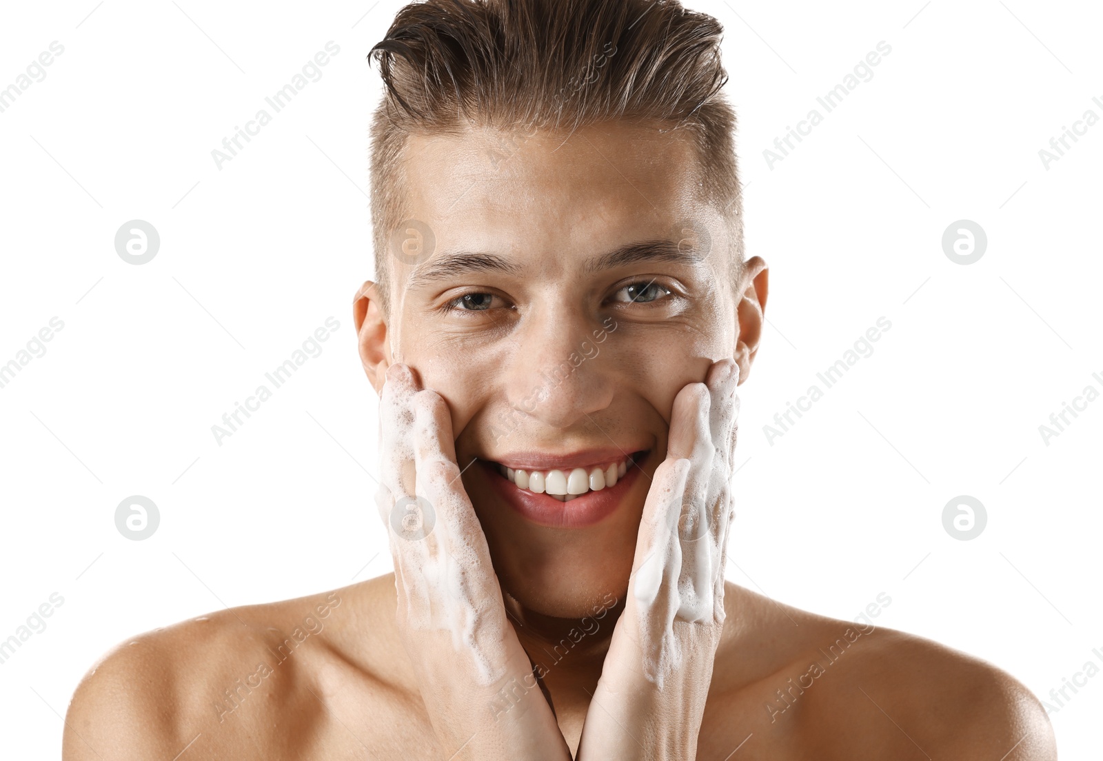 Photo of Smiling man washing his face with cleansing foam on white background