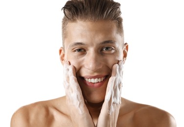 Photo of Smiling man washing his face with cleansing foam on white background