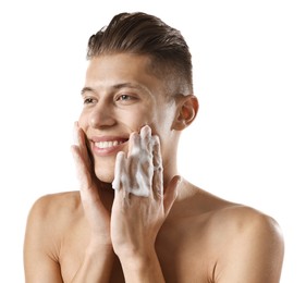 Photo of Smiling man washing his face with cleansing foam on white background