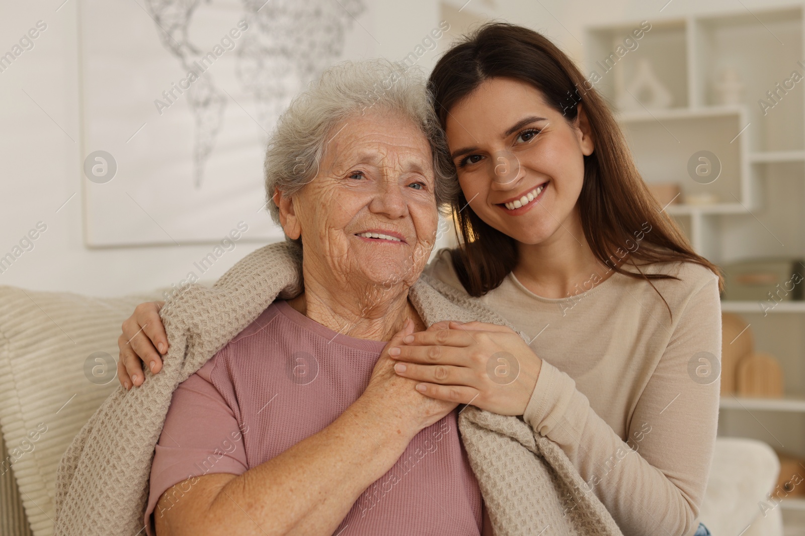 Photo of Portrait of happy granddaughter and her grandmother at home. Elderly care