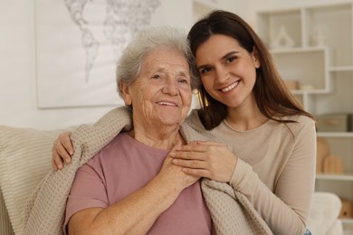 Portrait of happy granddaughter and her grandmother at home. Elderly care