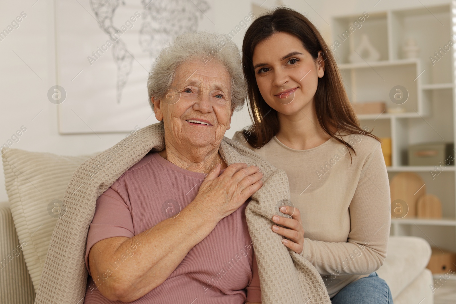 Photo of Portrait of happy granddaughter and her grandmother at home. Elderly care