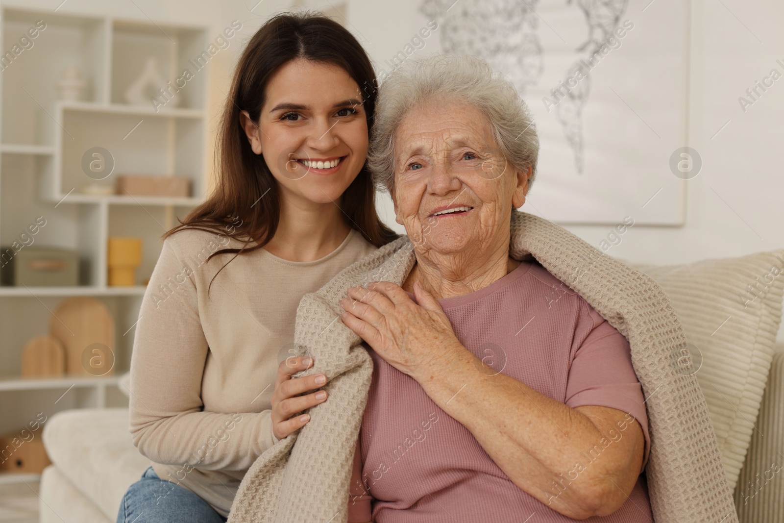 Photo of Portrait of happy granddaughter and her grandmother at home. Elderly care