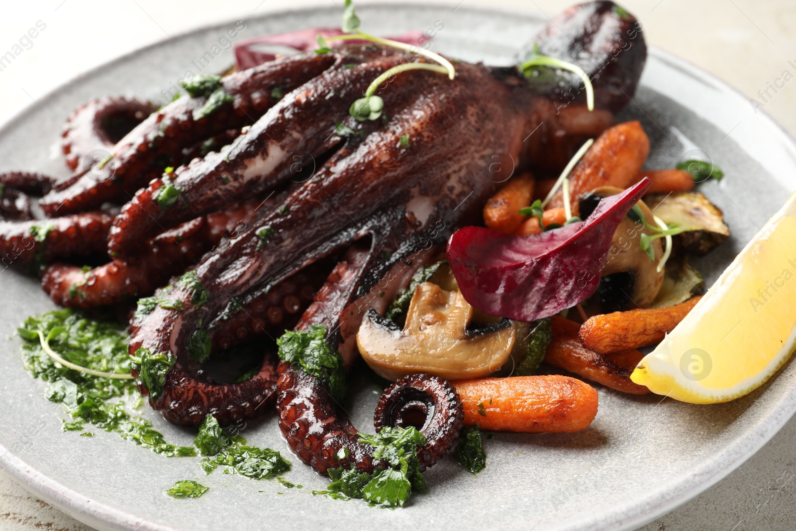 Photo of Roasted octopus with vegetables and mushrooms on table, closeup