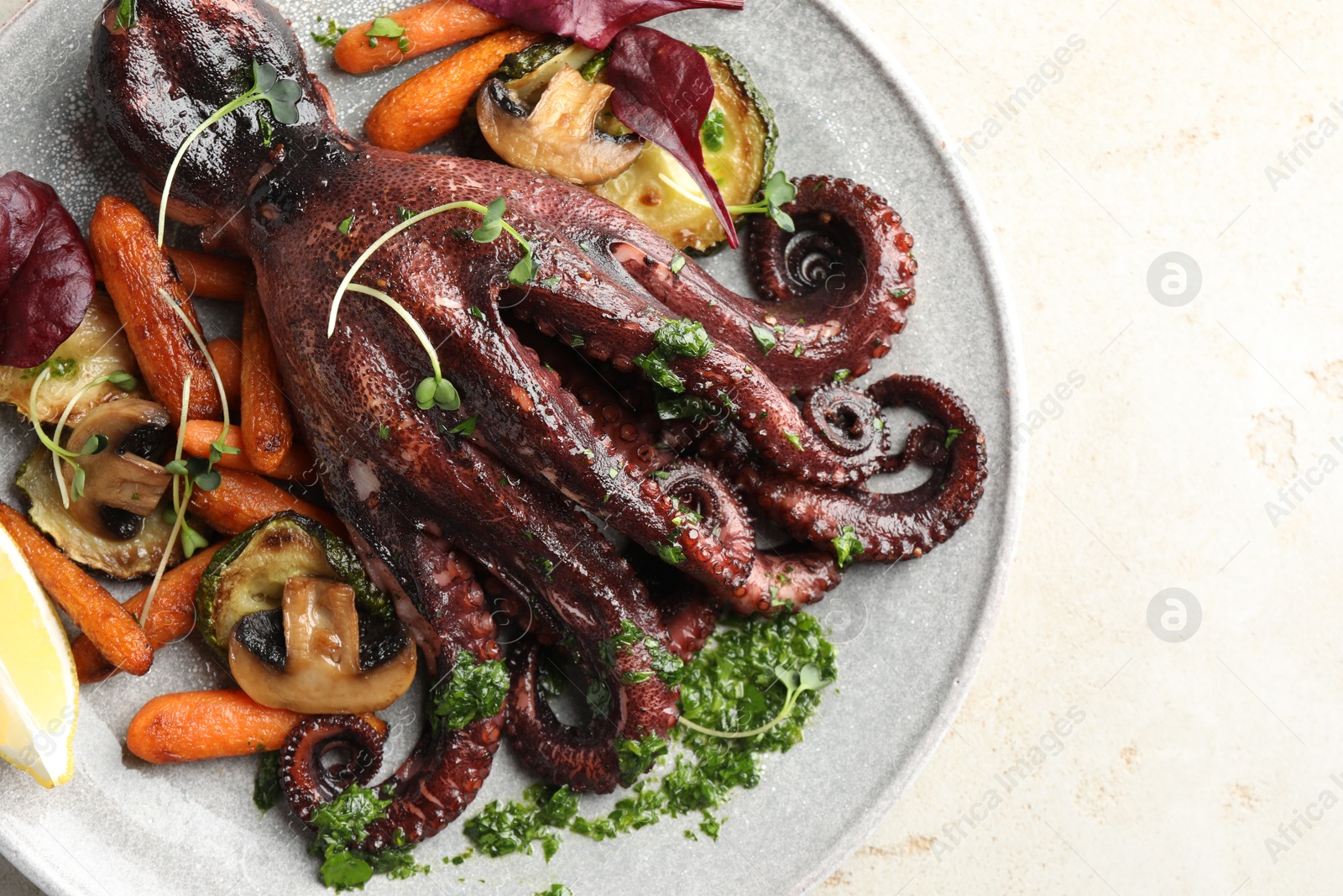 Photo of Roasted octopus with vegetables and mushrooms on light grey table, top view. Space for text