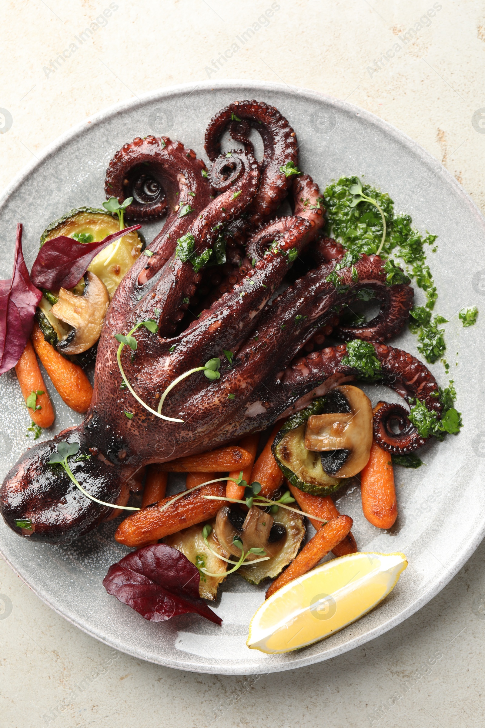 Photo of Roasted octopus with vegetables and mushrooms on light grey table, top view