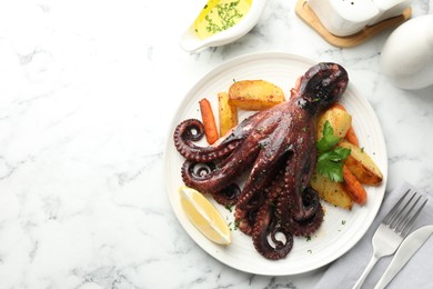 Photo of Roasted octopus with vegetables served on white marble table, flat lay. Space for text