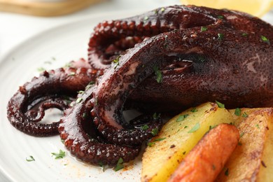 Photo of Roasted octopus with vegetables on plate, closeup