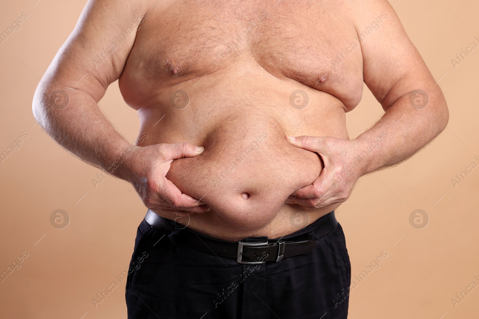 Photo of Man with excessive belly fat on beige background, closeup. Overweight problem