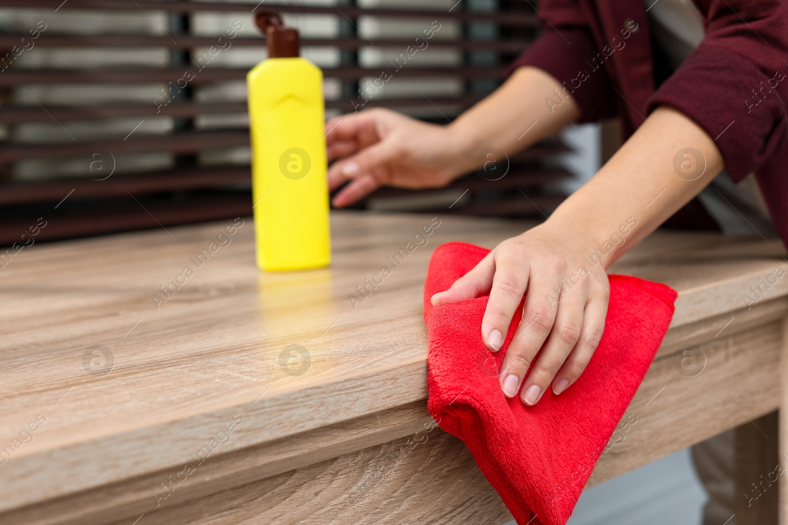 Photo of Woman polishing wooden table at home, closeup