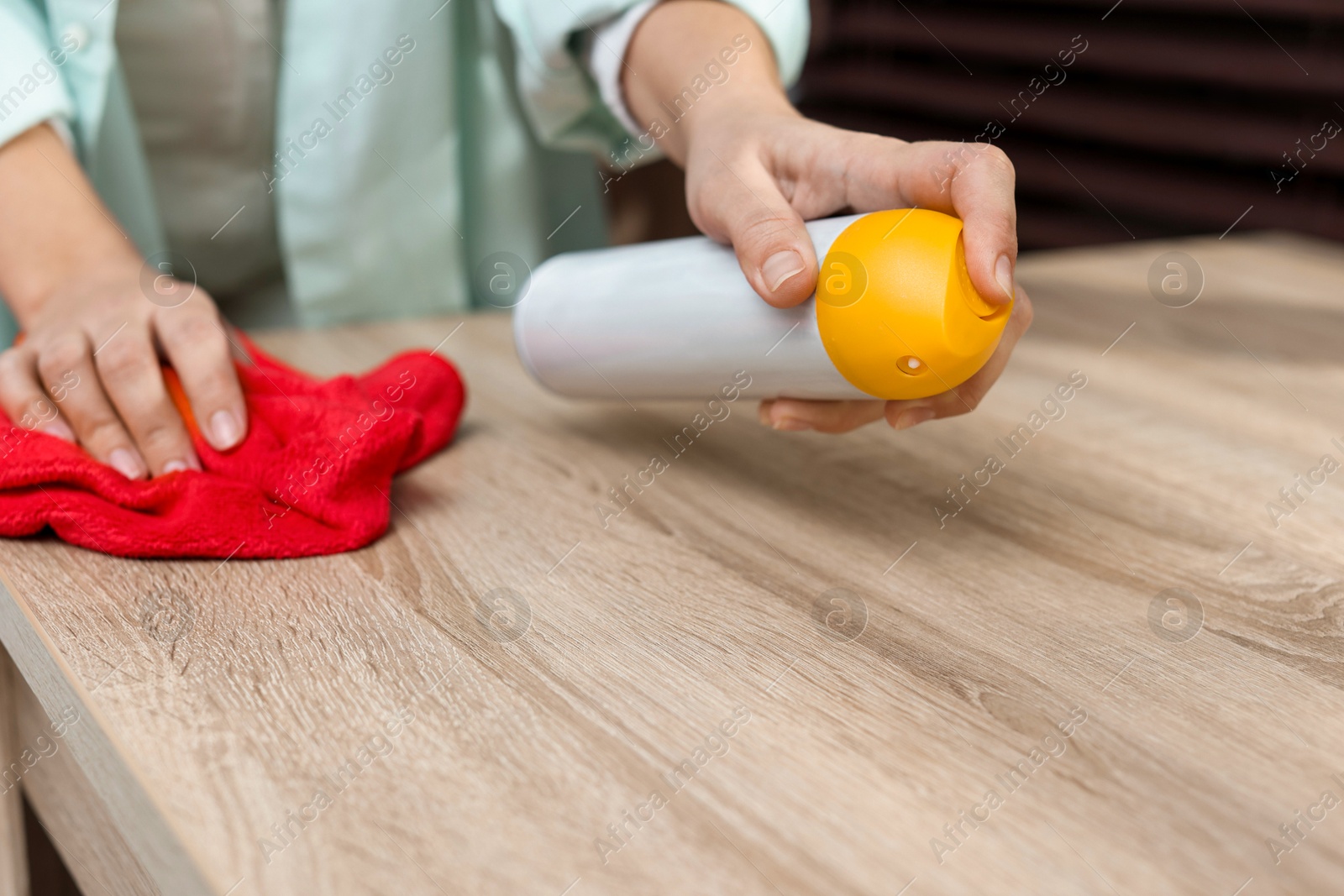 Photo of Woman polishing wooden table at home, closeup