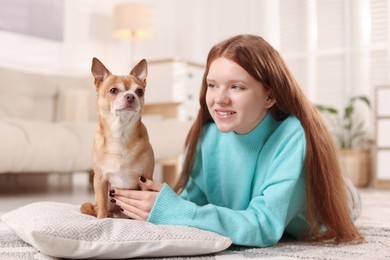 Photo of Teenage girl with her cute Chihuahua dog at home