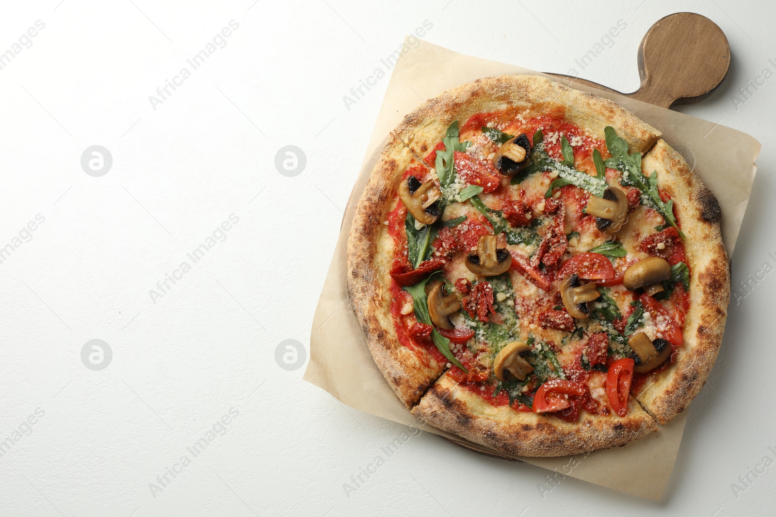 Photo of Tasty pizza with mushrooms, tomatoes and arugula on white table, top view. Space for text