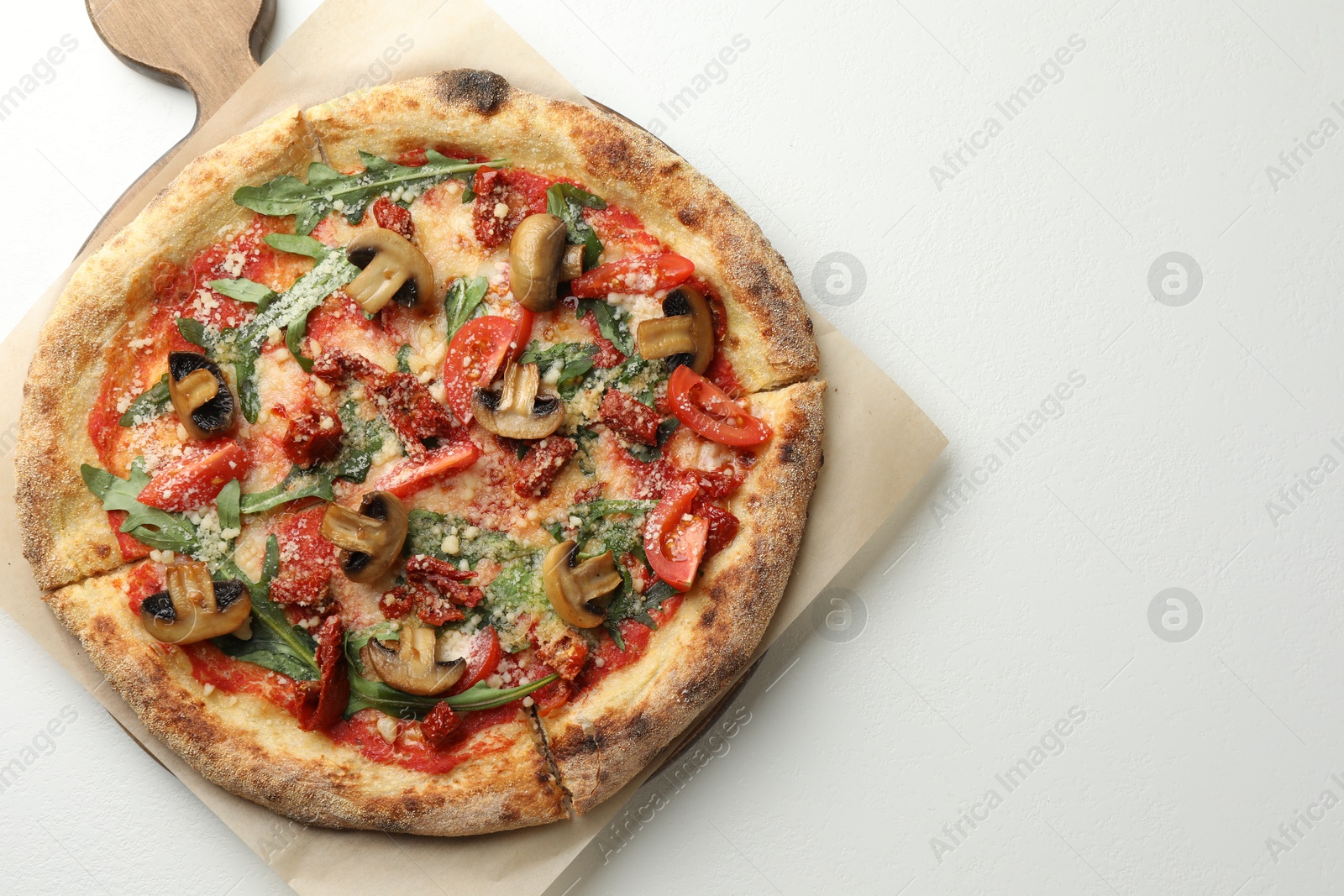 Photo of Tasty pizza with mushrooms, tomatoes and arugula on white table, top view. Space for text