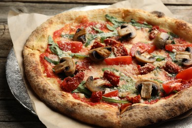 Tasty pizza with mushrooms, tomatoes and arugula on wooden table, closeup