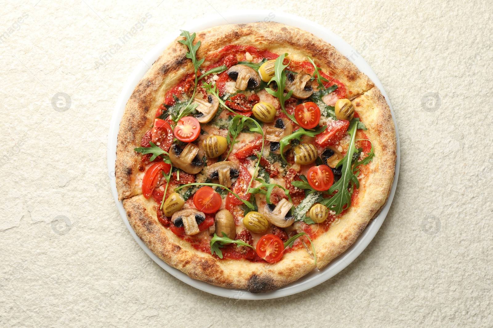 Photo of Tasty pizza with mushrooms, olives, tomatoes and arugula on white textured table, top view