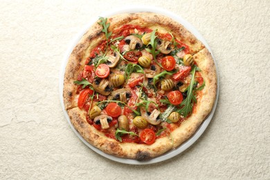 Tasty pizza with mushrooms, olives, tomatoes and arugula on white textured table, top view