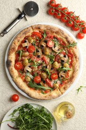 Tasty pizza with mushrooms, olives, tomatoes and arugula served on white textured table, flat lay