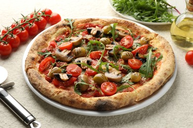 Photo of Tasty pizza with mushrooms, olives, tomatoes and cutter on white textured table, closeup