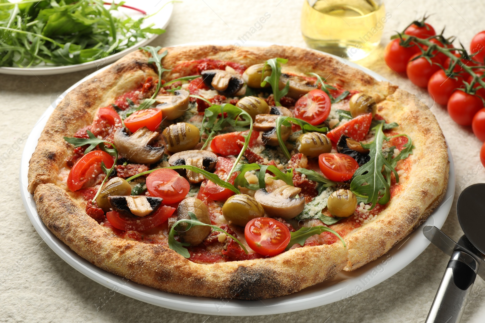 Photo of Tasty pizza with mushrooms, olives, tomatoes and cutter on white textured table, closeup