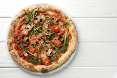 Tasty pizza with mushrooms, tomatoes and arugula on white wooden table, top view. Space for text