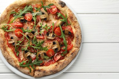 Photo of Tasty pizza with mushrooms, tomatoes and arugula on white wooden table, top view. Space for text