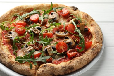 Photo of Tasty pizza with mushrooms, tomatoes and arugula on white wooden table, closeup