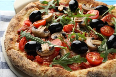 Photo of Tasty pizza with mushrooms, black olives and arugula on table, closeup