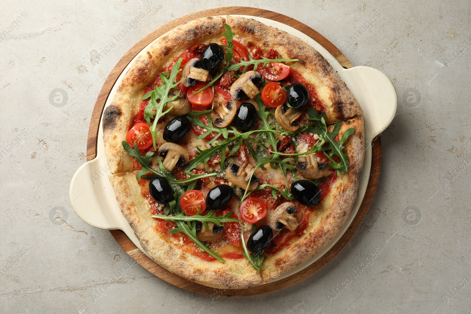 Photo of Tasty pizza with mushrooms, olives and arugula on light grey table, top view