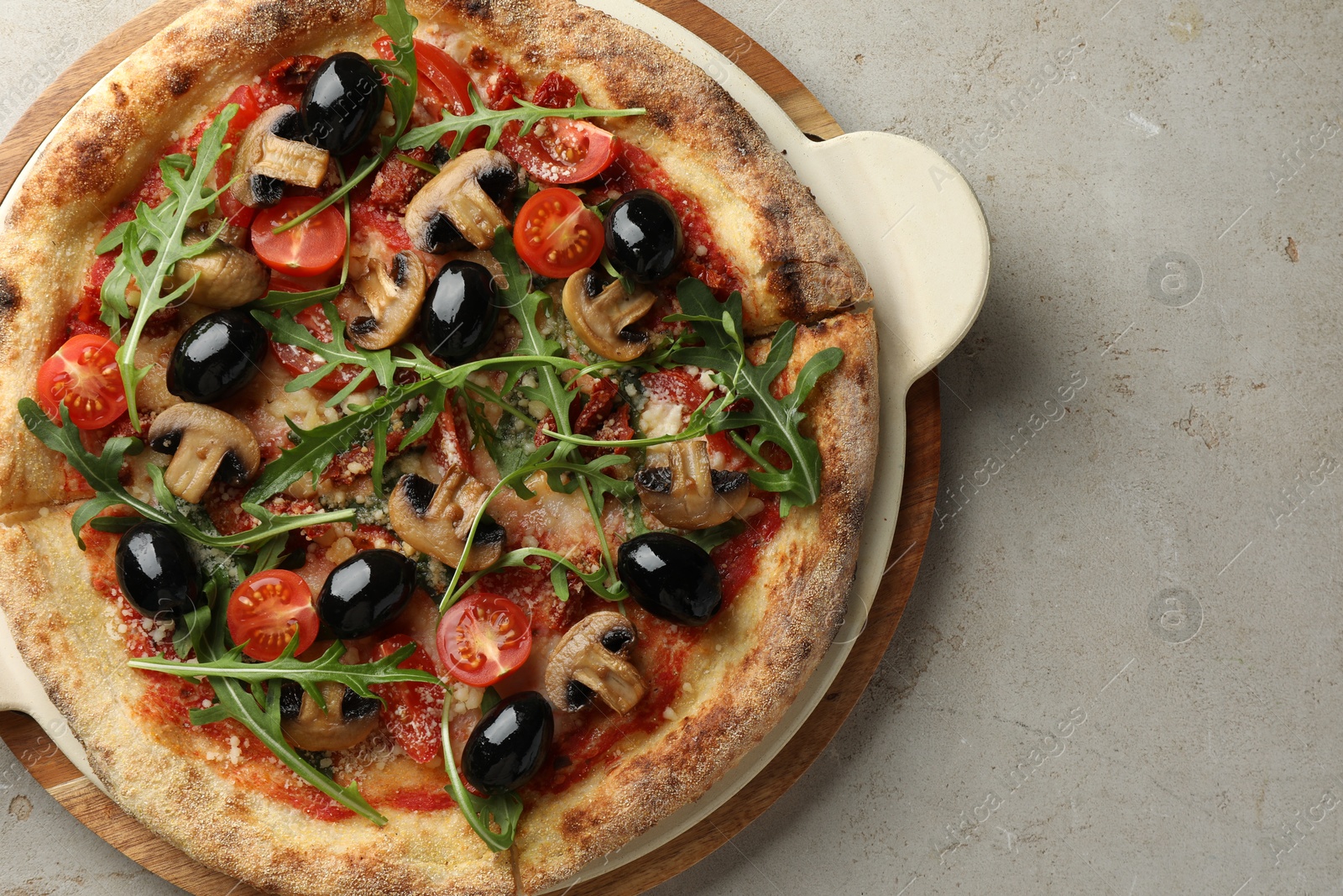 Photo of Tasty pizza with mushrooms, olives and arugula on light grey table, top view. Space for text