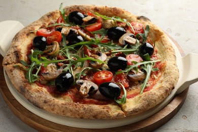 Tasty pizza with mushrooms, black olives and arugula on light grey table, closeup