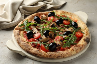 Photo of Tasty pizza with mushrooms, black olives and arugula on light grey table, closeup