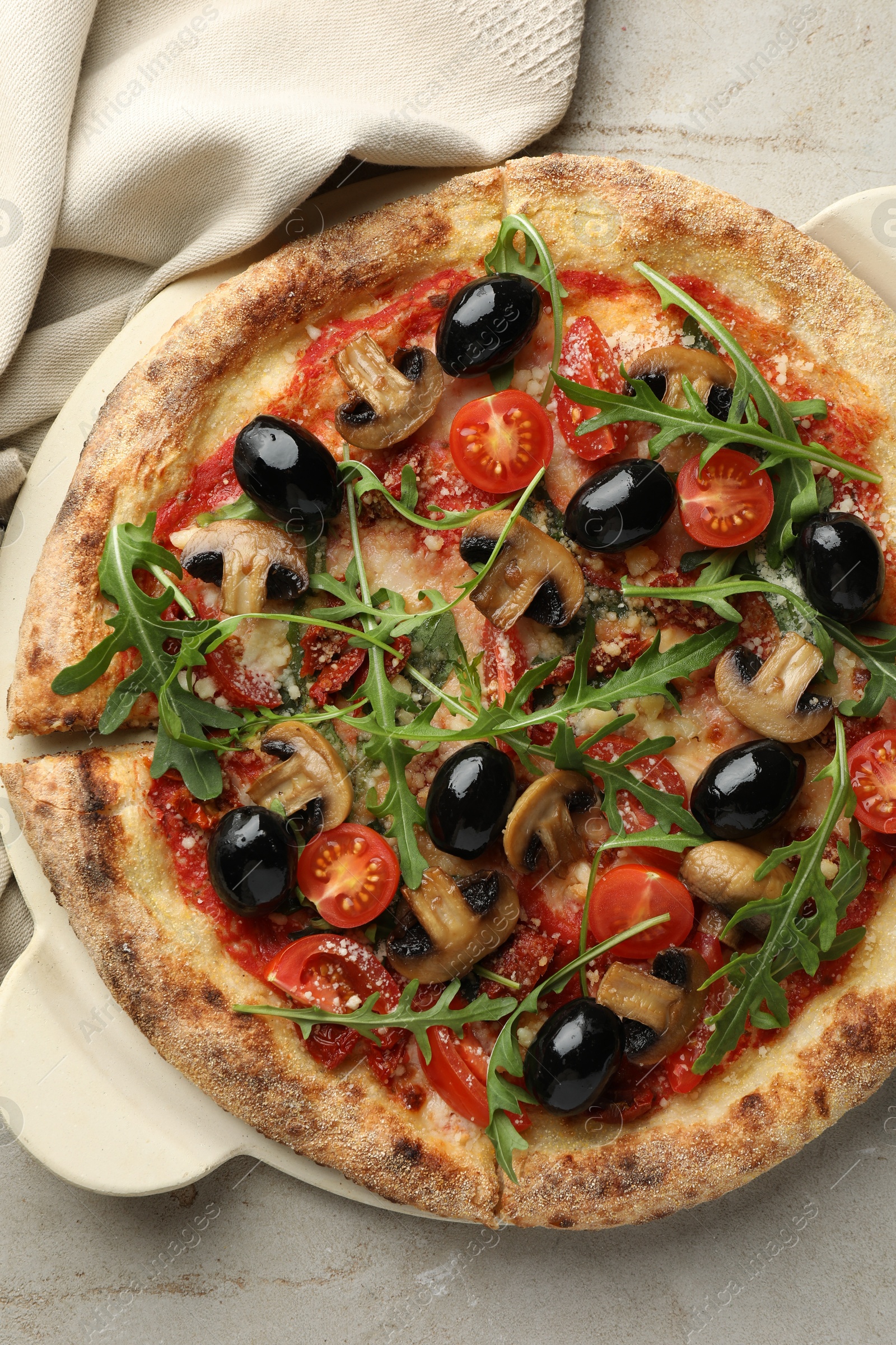 Photo of Tasty pizza with mushrooms, olives and arugula on light grey table, top view