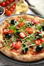 Photo of Tasty pizza with tomatoes, olives and arugula on light tiled table, closeup