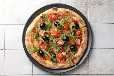 Photo of Tasty pizza with olives and arugula on light tiled table, top view