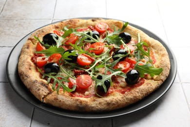 Photo of Tasty pizza with tomatoes, olives and arugula on light tiled table, closeup