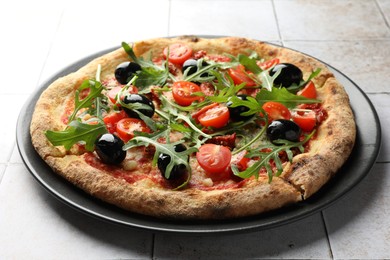 Tasty pizza with tomatoes, olives and arugula on light tiled table, closeup