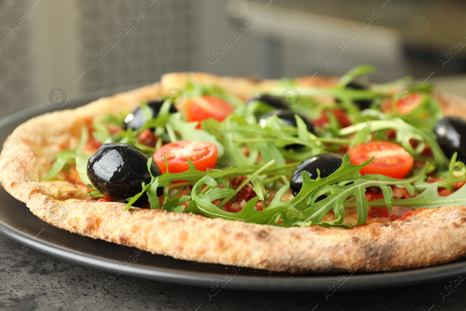 Photo of Delicious pizza with olives, cherry tomatoes and arugula on grey table indoors, closeup