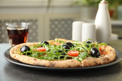 Delicious pizza with olives, cherry tomatoes, arugula and soda drink on grey table indoors, closeup