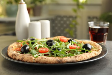 Delicious pizza with olives, cherry tomatoes, arugula and soda drink on grey table indoors, closeup