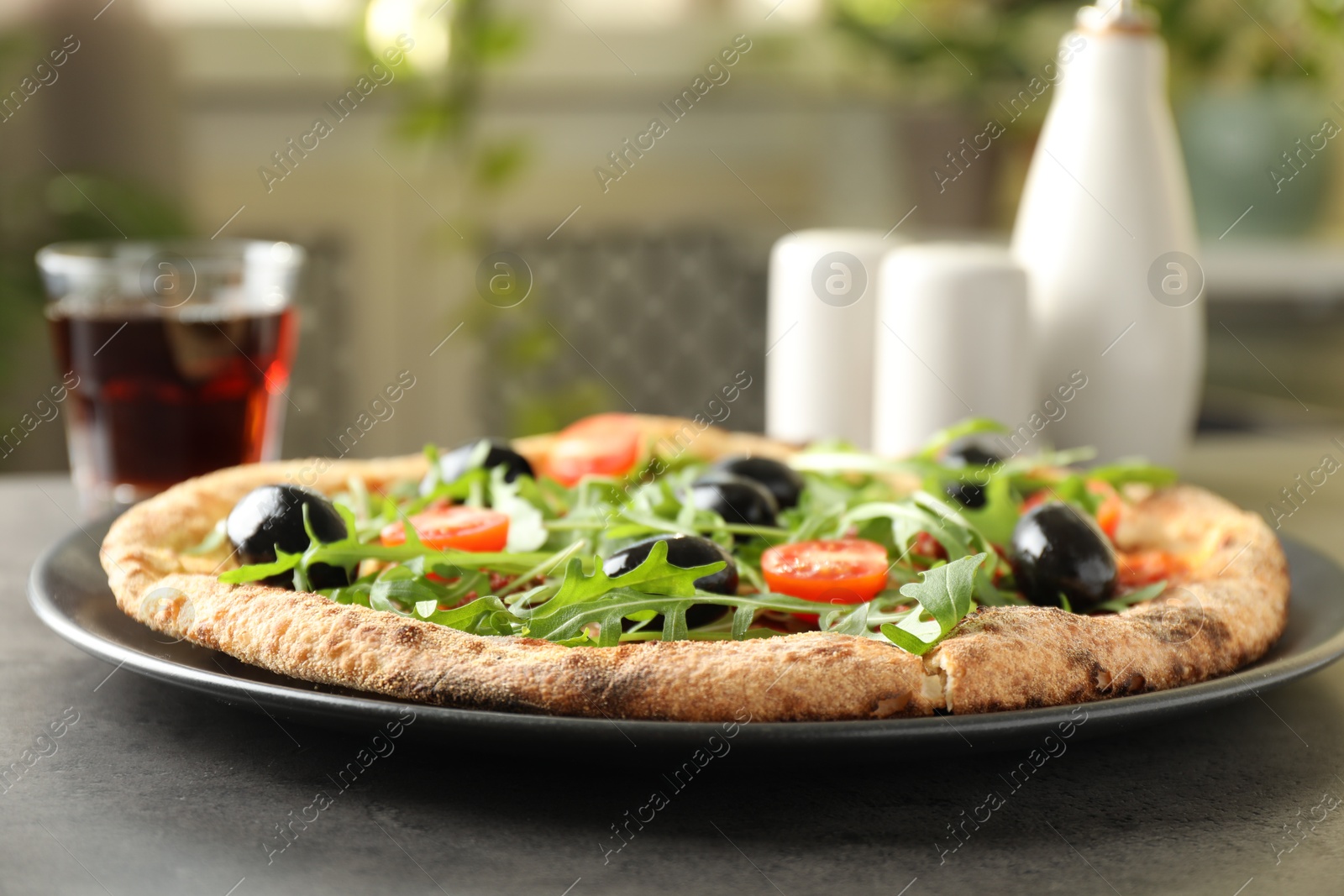 Photo of Delicious pizza with olives, cherry tomatoes, arugula and soda drink on grey table indoors, closeup