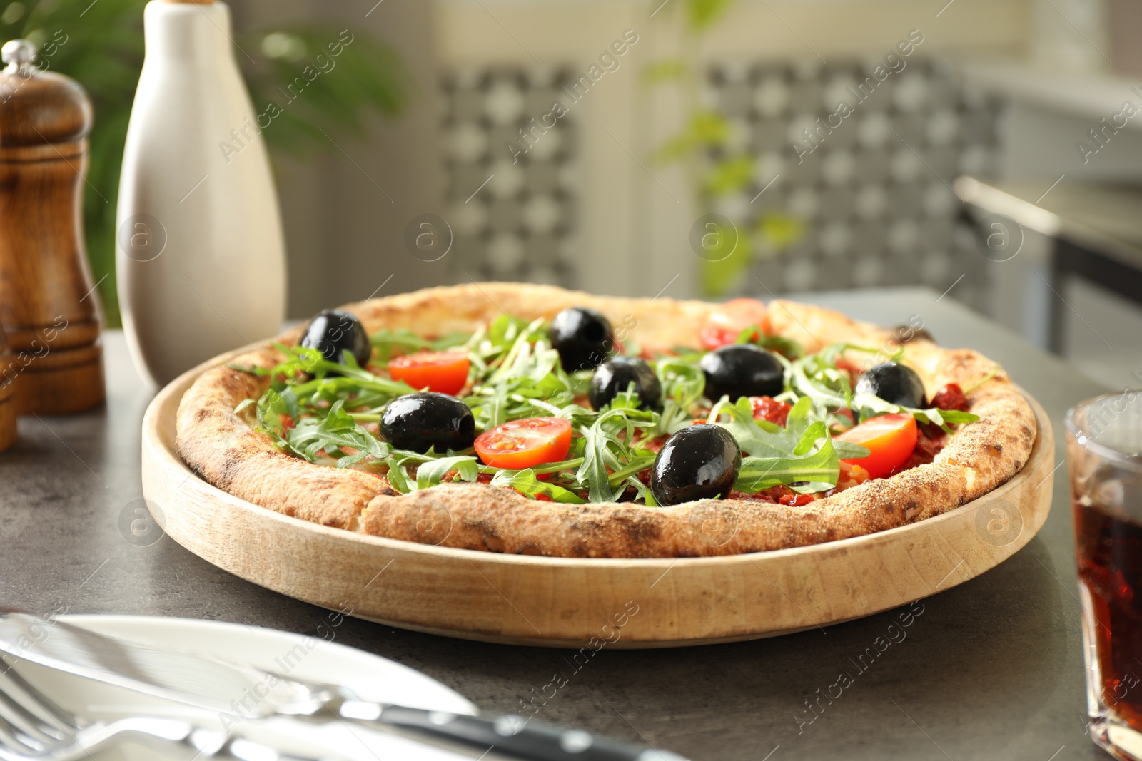 Photo of Delicious pizza with olives, cherry tomatoes and arugula on grey table indoors, closeup