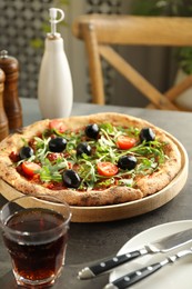 Delicious pizza with olives, cherry tomatoes, arugula and soda drink on grey table indoors, closeup