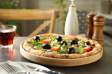 Delicious pizza with olives, cherry tomatoes, arugula and soda drink on grey table indoors, closeup