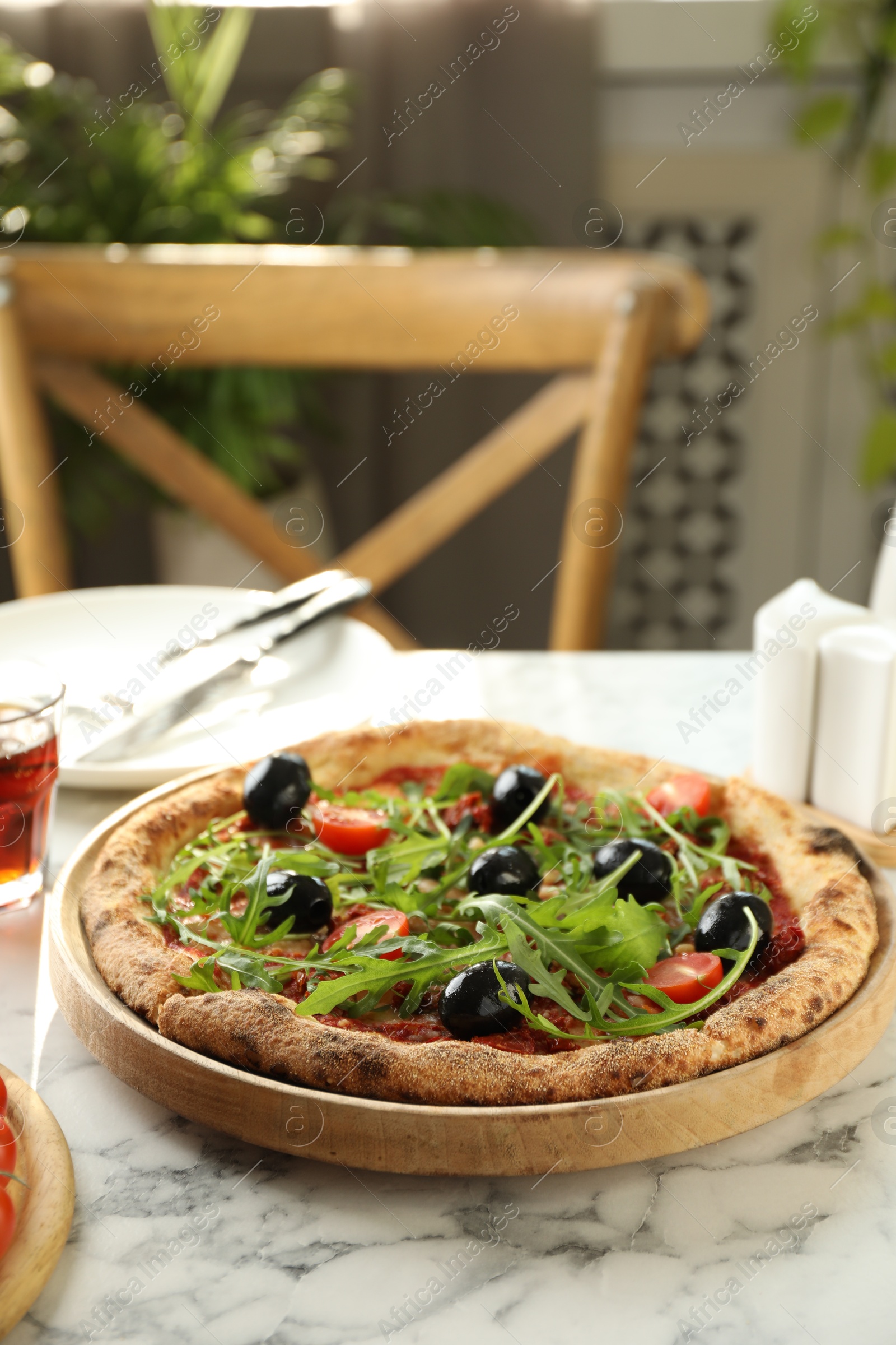 Photo of Delicious pizza with olives, cherry tomatoes and arugula on white marble table indoors, closeup