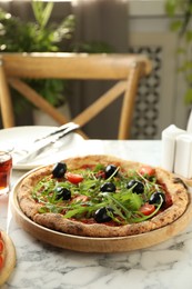 Photo of Delicious pizza with olives, cherry tomatoes and arugula on white marble table indoors, closeup