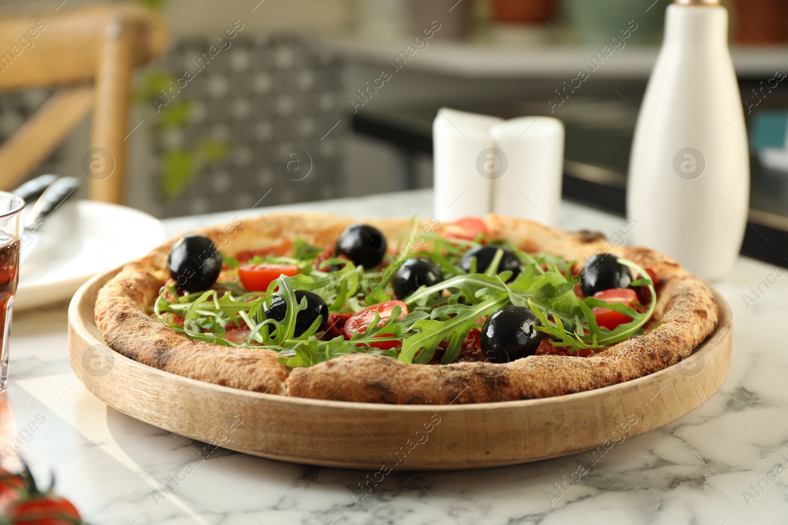 Photo of Delicious pizza with olives, cherry tomatoes and arugula on white marble table indoors, closeup