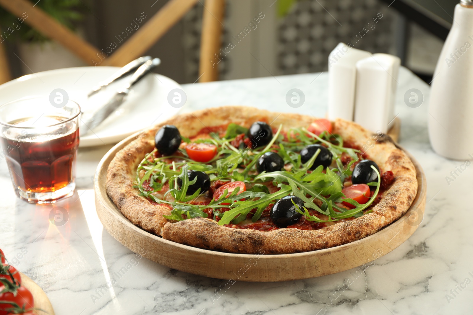 Photo of Delicious pizza with olives, cherry tomatoes, arugula and soda drink on white marble table indoors, closeup