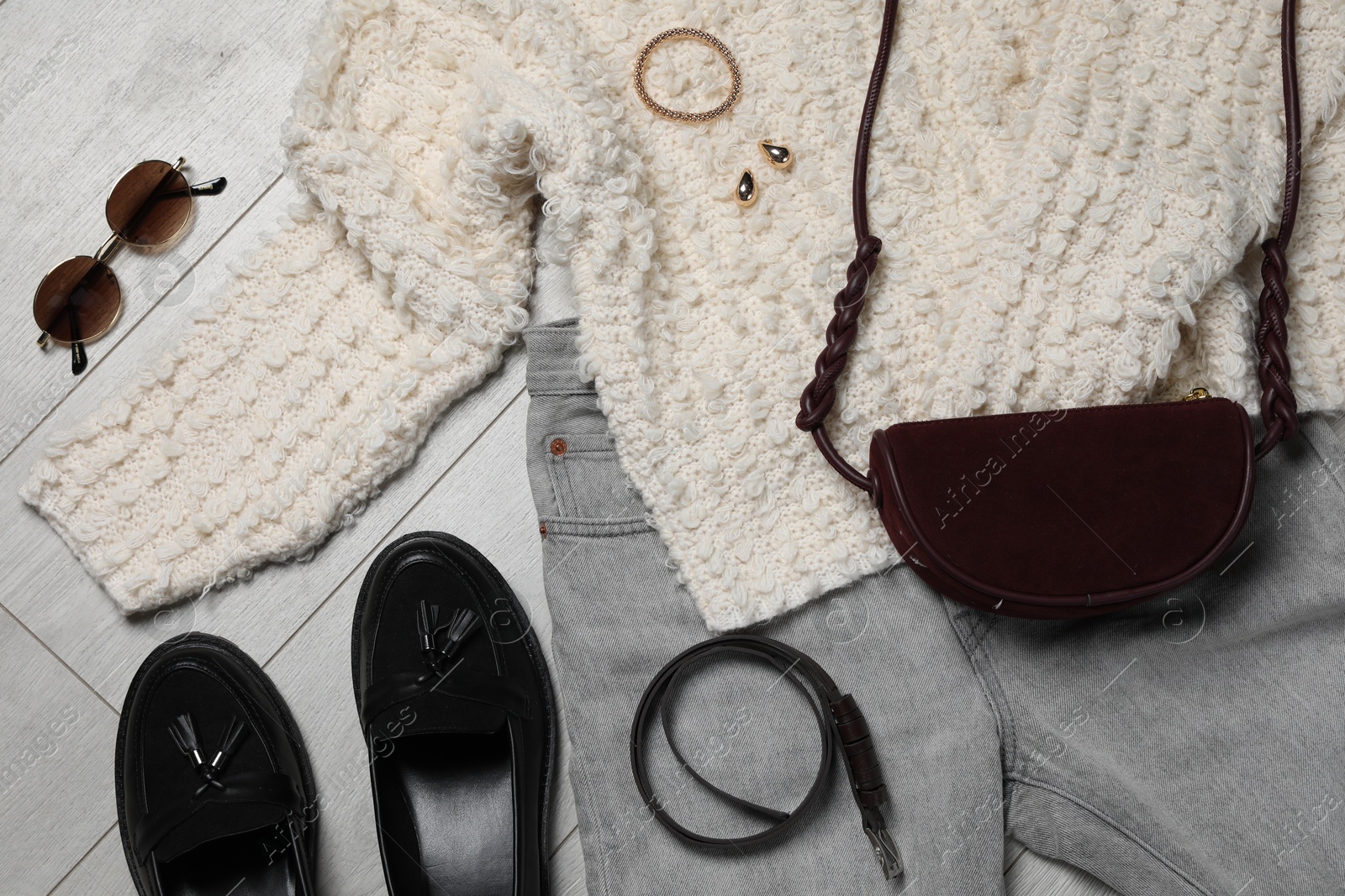 Photo of Stylish women's clothes and different accessories on light grey wooden table, flat lay