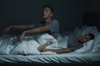 Image of Young man suffering from sleepwalking at home, double exposure